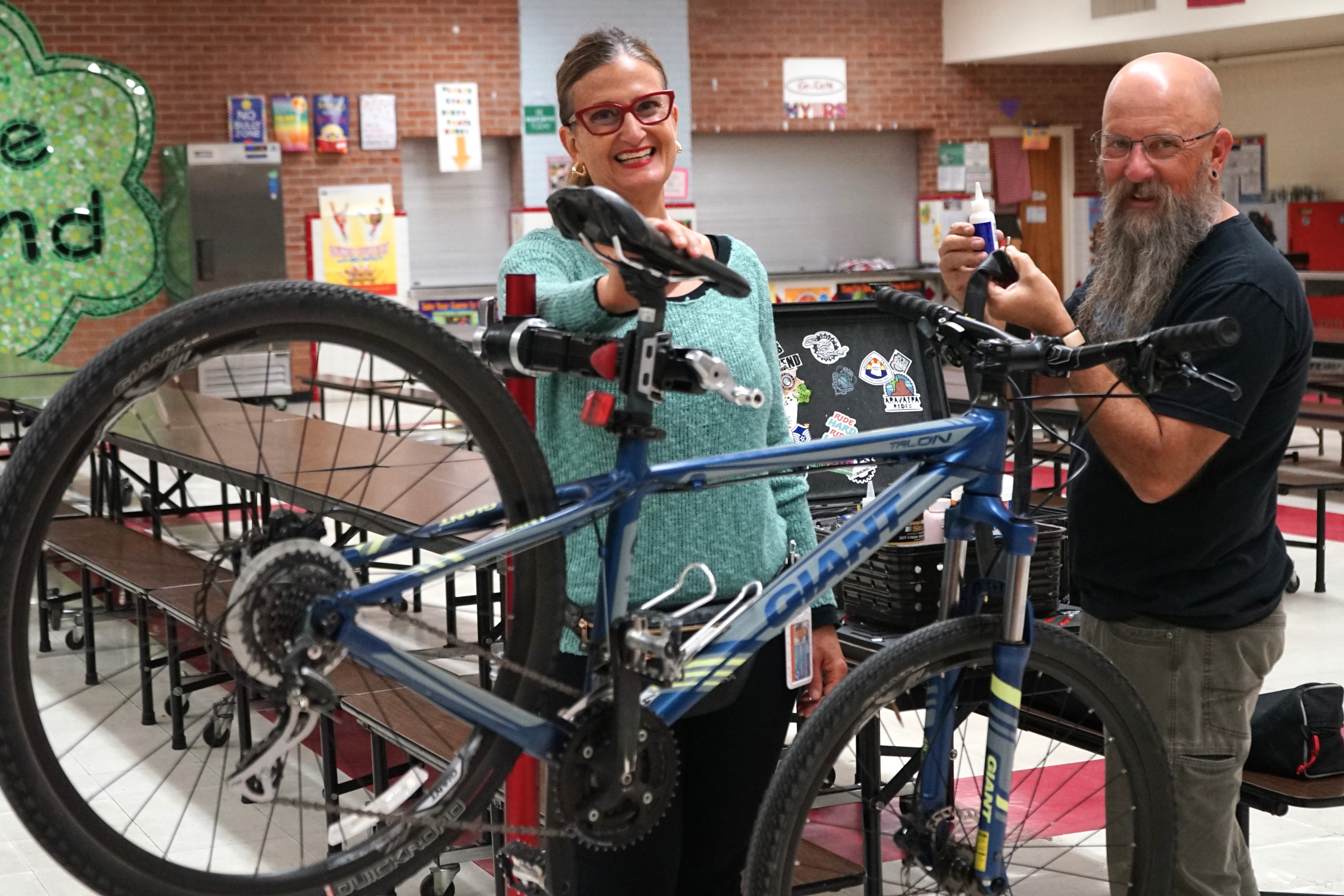 A woman and a man show off a bike