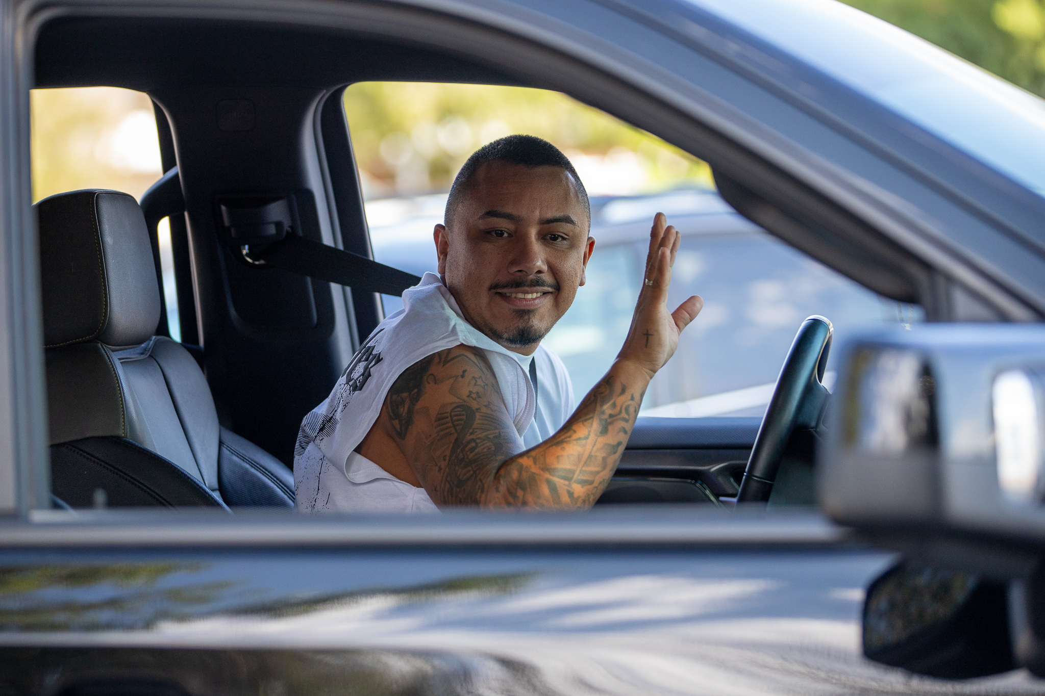 A dad waves from his car