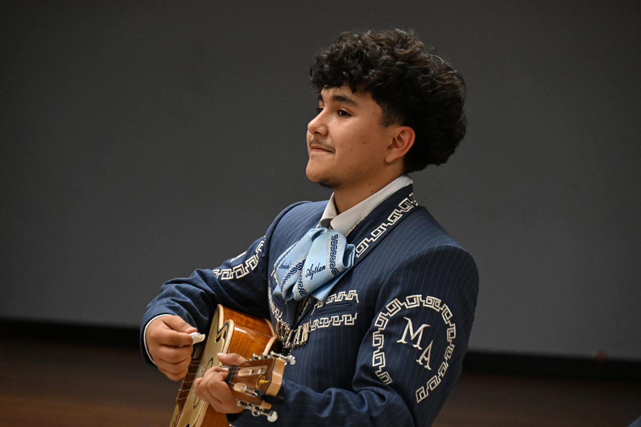 A teen boy plays guitar as part of Mariachi Aztlan's performance