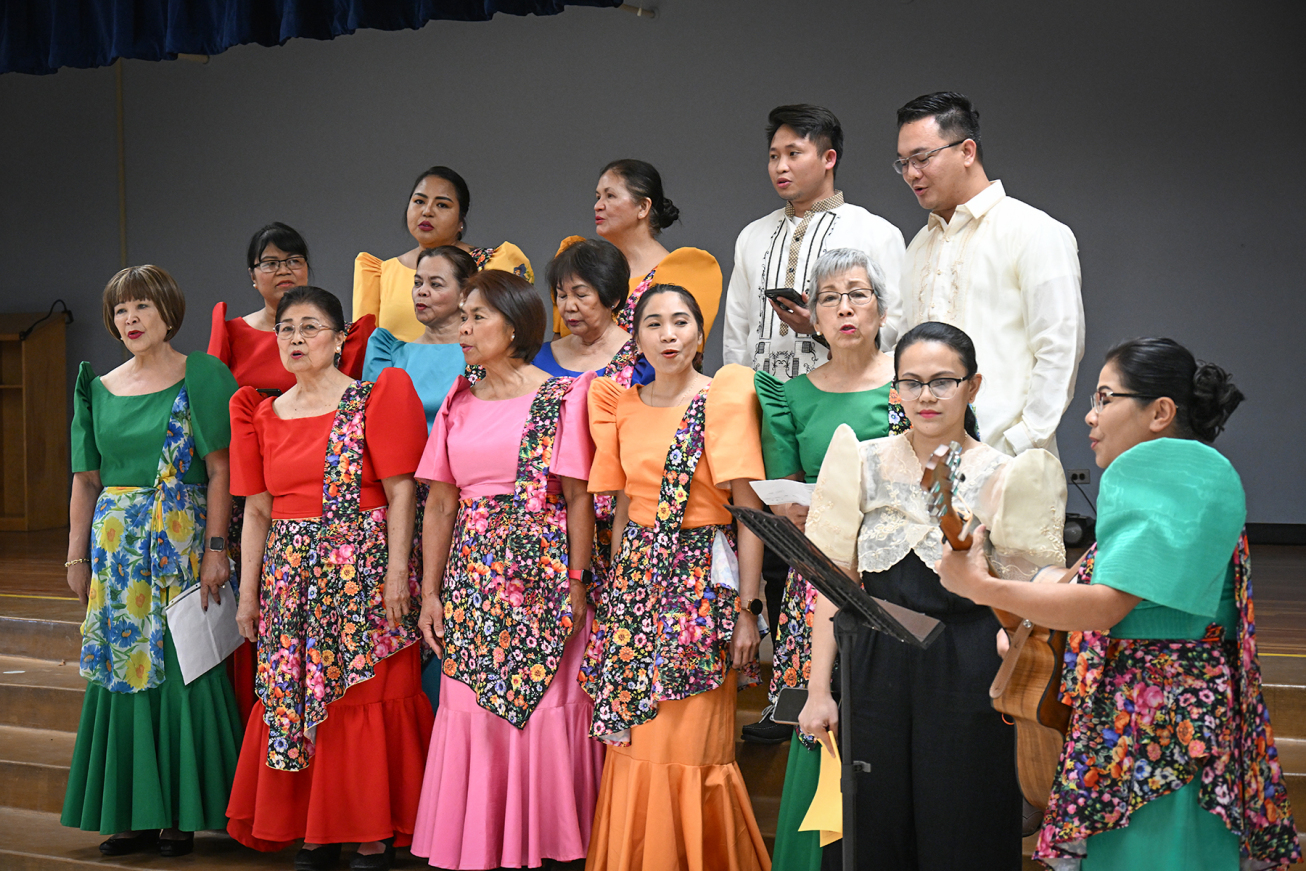 A group of singers perform in traditional brightly colored dresses.